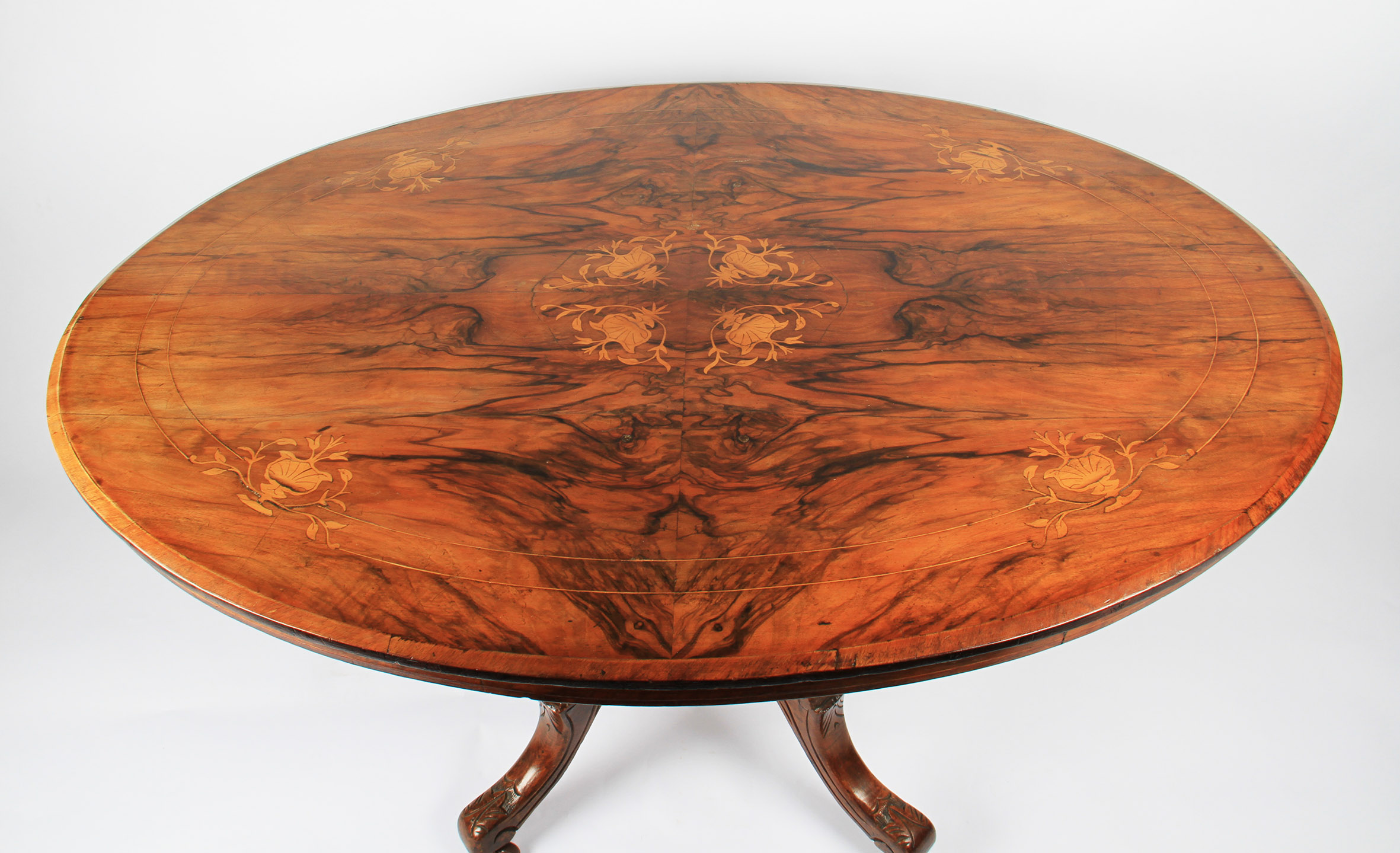 A Victorian oval walnut and inlaid tilt top table on turned pillar base with splayed feet, length - Image 2 of 2