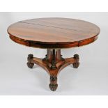 A 19th Century rosewood circular tilt top table with eternal patterned brass edging, all on tri-form