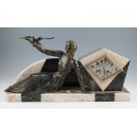 A French Art Deco mantle clock, depicting a seated bronzed spelter female reclining figure, a bird