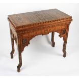 A late Victorian Anglo Indian games table with extensively inlaid body and interior, the hinged