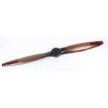 A reproduction aeroplane propeller with red painted ends with brass tips and edging, length 186cm.