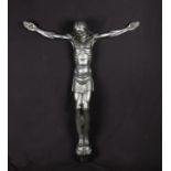 A wall mounted sculpture of a Christ corpus with steel metal finish, set with red glass eyes, signed