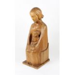 A 20th Century carved wooden sculpture of a seated Madonna with child on her lap, signed to side ‘