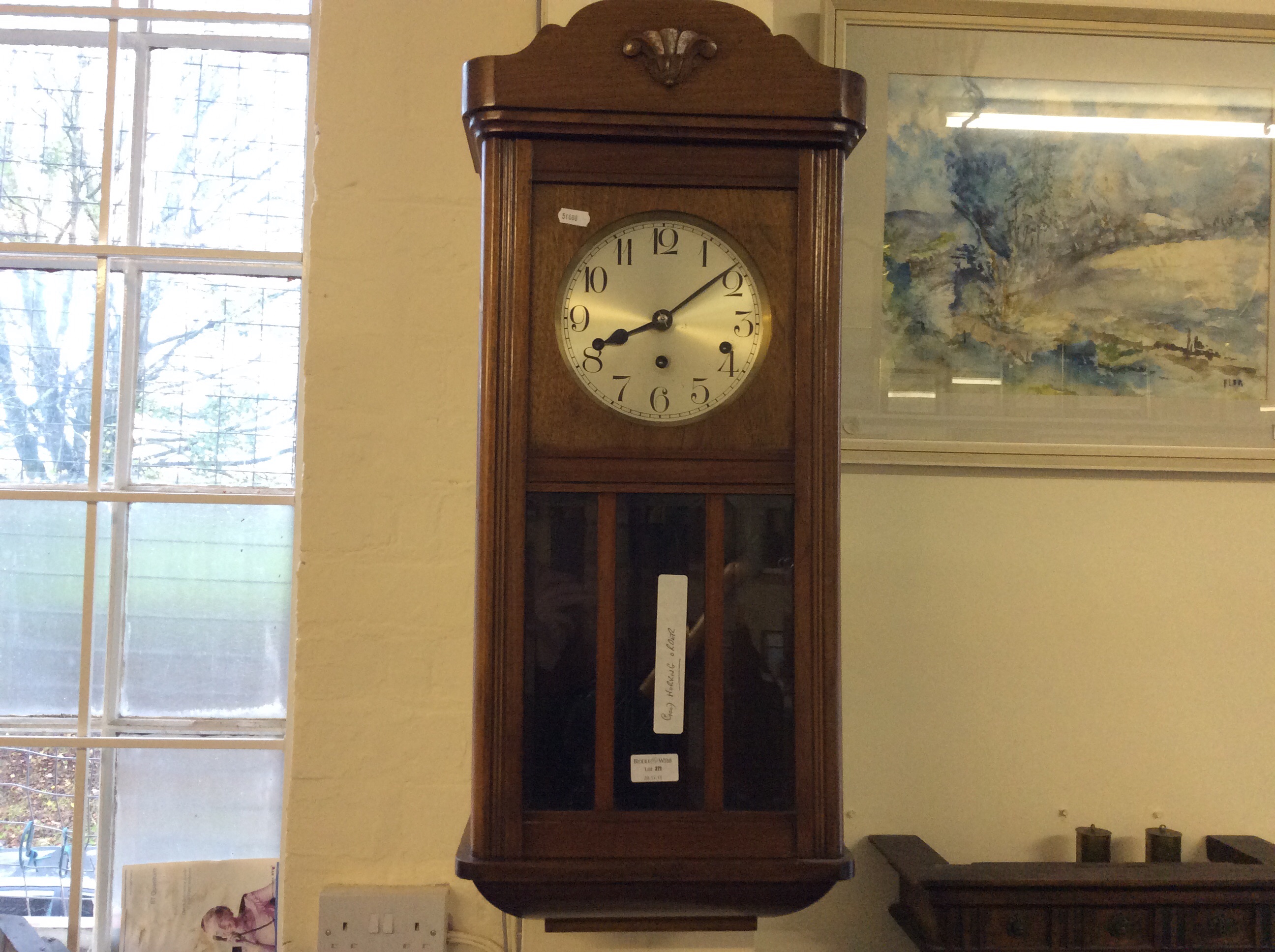 A mahogany wall mounted clock with pendulum and chimes, in good working order.