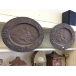 A pair of copper plates with cast pastoral images.