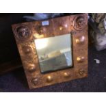 An Arts and Crafts style copper mirror decorated with arts and crafts female motif.