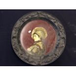 A painted detailed metalwork dish with the image of a soldier.