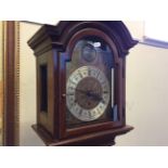 A mahogany grandfather clock with detailed metal clock face.