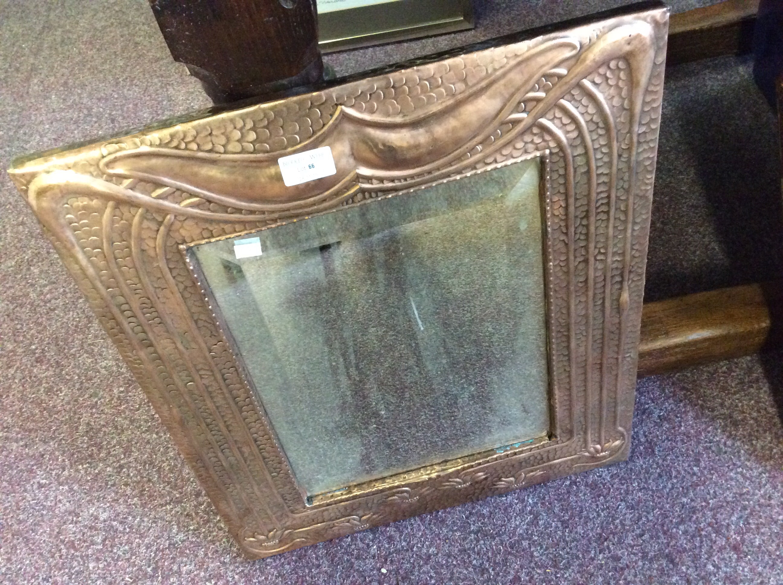 An Arts and Crafts style copper mirror with glial decoration.