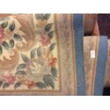 A pink and blue oriental style rug with floral pattern.