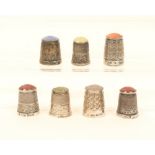 Seven English stone top silver thimbles, including examples by James Swann & Son (x4), two with
