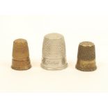 Three inscribed thimbles, comprising; a brass example "God Help Us", another "For a Friend", and a