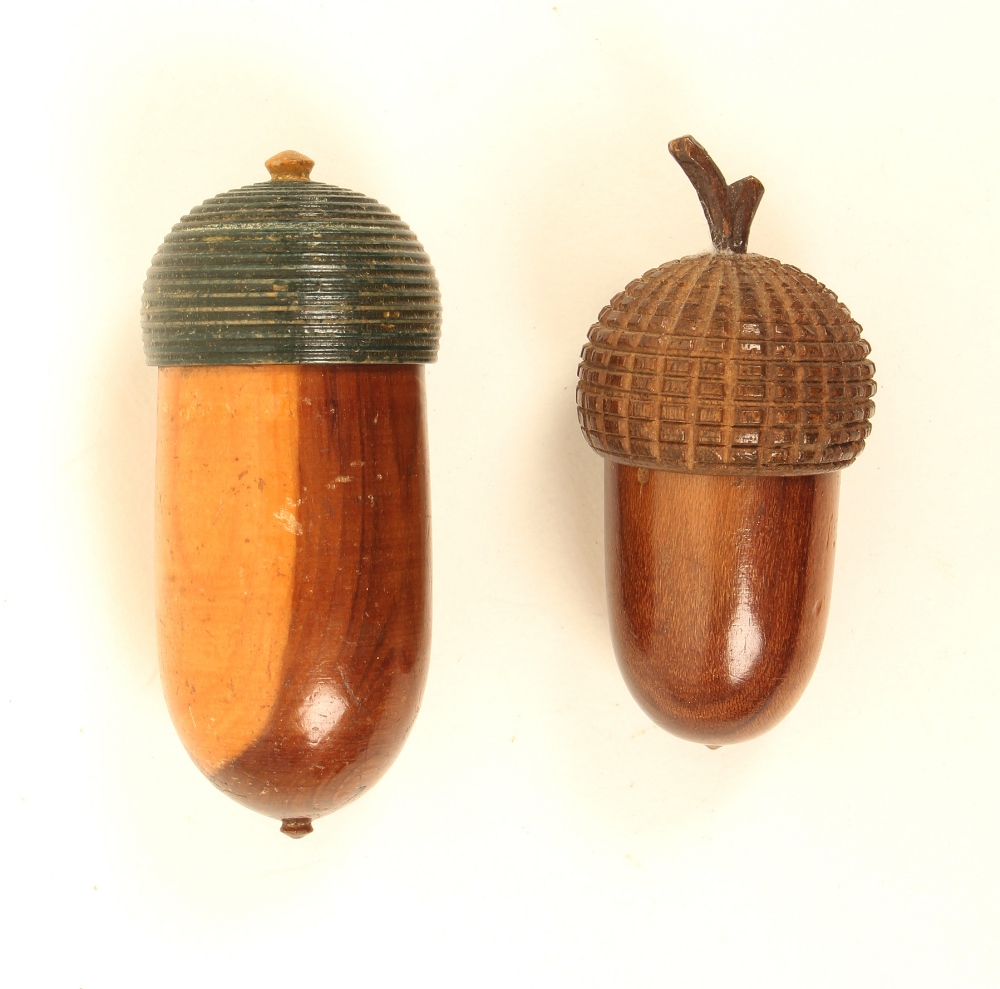 Two turned wooden acorn form thimble cases, comprising; an early 19th century yew wood example