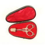 A cased pair of silver handled scissors and a thimble, matched, the scissors with floral and