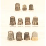 Eleven American white metal thimbles, most with decorative borders, including "The Cow …", rural