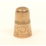 An English gilt metal thimble, the broad frieze with leaf scroll engraving, divided by a cartouche