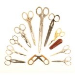 Eleven pairs of scissors, comprising; a larger steel pair with floral arms and loops, 20cm, a button
