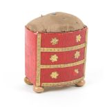 An unusual Georgian pincushion modelled as a bow front chest of three drawers, in red grained