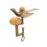 A brass hemming bird clamp, the rectangular frame with leaf and floral decoration below a pincushion