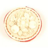 An ivory pincushion of disc form, one side well carved with  a group of leaves, flowers and fruit,