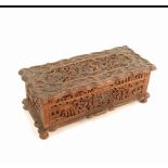 A 19th century Chinese carved wood rectangular box, the lid carved with a panel of figures amid