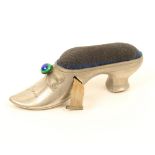 A white metal novelty tape measure in the form of a lady's shoe, blue velvet inset worn, the bow