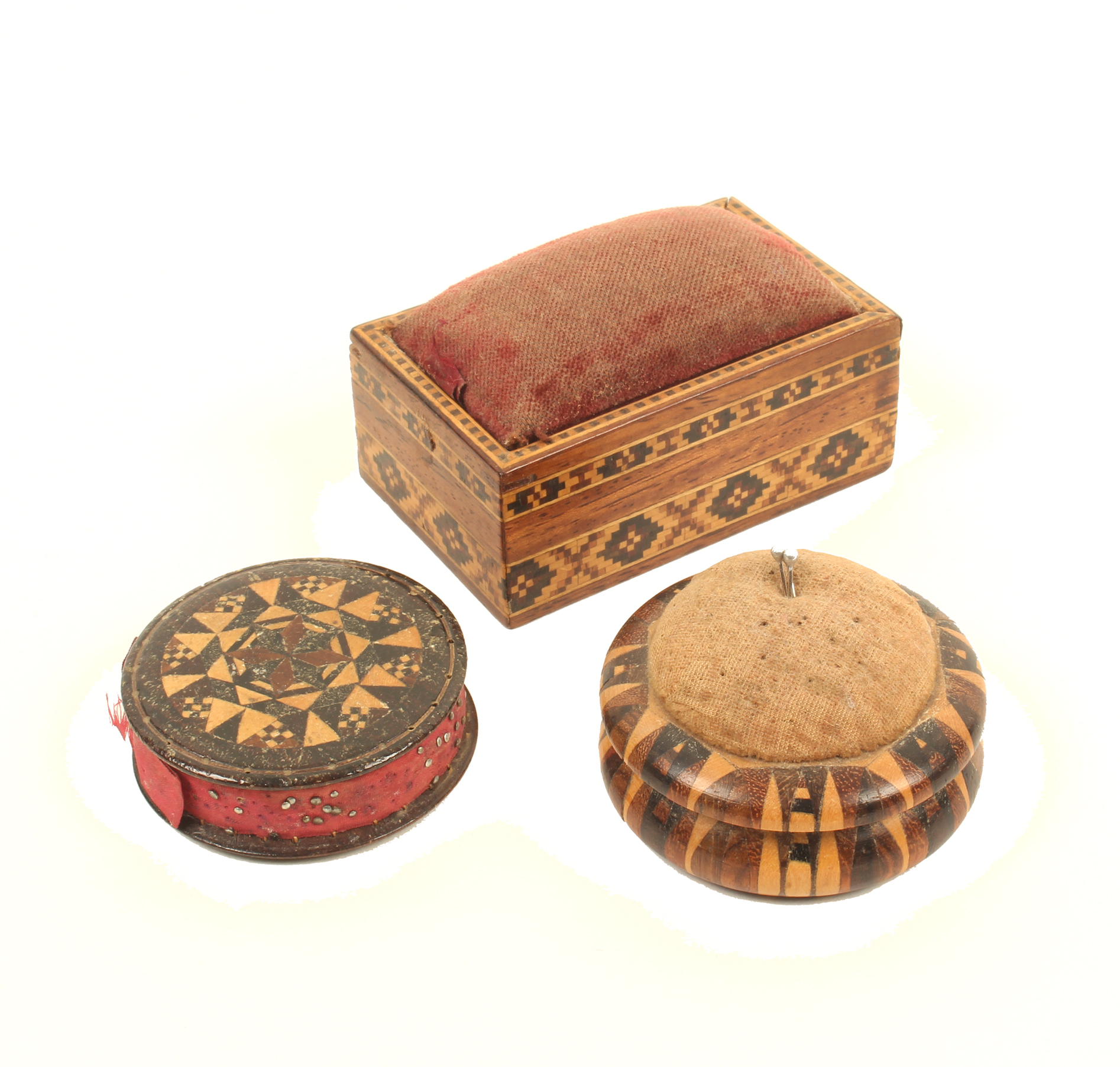 Three Tunbridge ware pincushions, comprising; a disc form example with stickware panels, 4.7cm