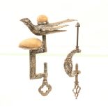 Two sewing clamps, comprising; a silvered brass hemming bird example, the rectangular frame