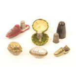 Six thimble cases, comprising; a mother-of-pearl egg, 4cm, a cast metal walnut, a brass shoe with