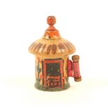 A painted Tunbridge ware cottage form tape measure, of cylinder form, painted with door, windows and