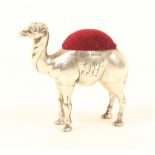 An Edwardian novelty silver pincushion in the form of a camel, with red velvet cushion and