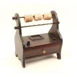 A stained wooden reel stand, with two reel rods over a drawer form base, with two thimble stands,