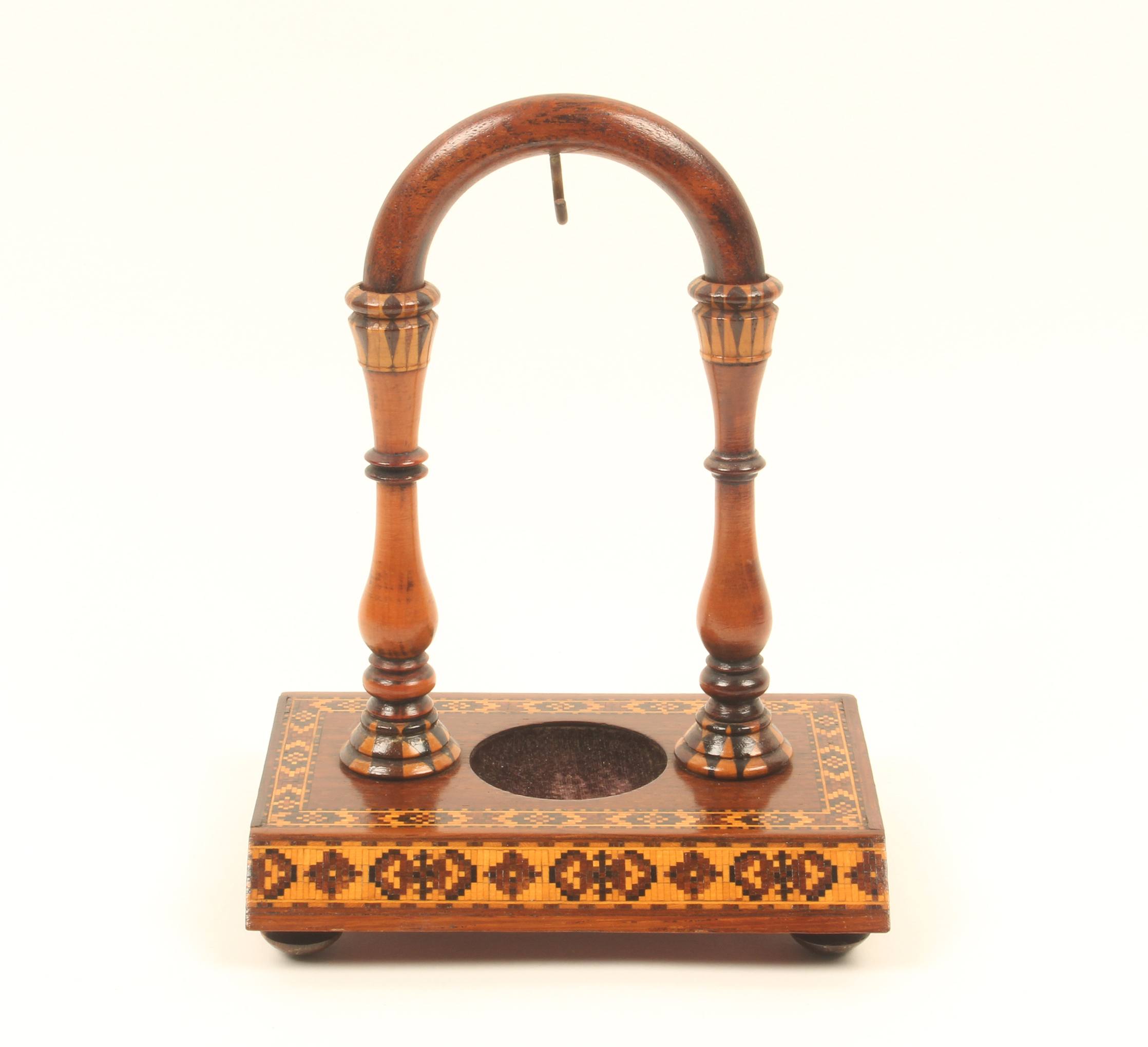 A Tunbridge ware rosewood watch stand, the rectangular base on four turned feet and canted to the