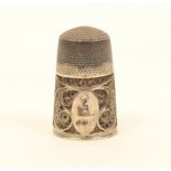 An early 19th century English silver filigree thimble, the quill work border with an oval cartouche,