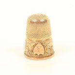 A 19th century gold thimble, the frosted frieze with a design of leaf scrolls divided by an