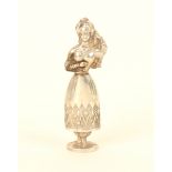 A continental figural silver needlecase in the form of a woman in traditional costume, one hand held