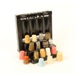 A Dorcas black plastic 'odeonesque' thimble display stand, with a selection of thimbles, including