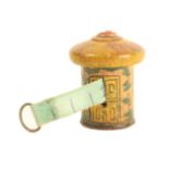 A painted Tunbridge ware cylinder form tape measure, in the form of a cottage, replacement tape in