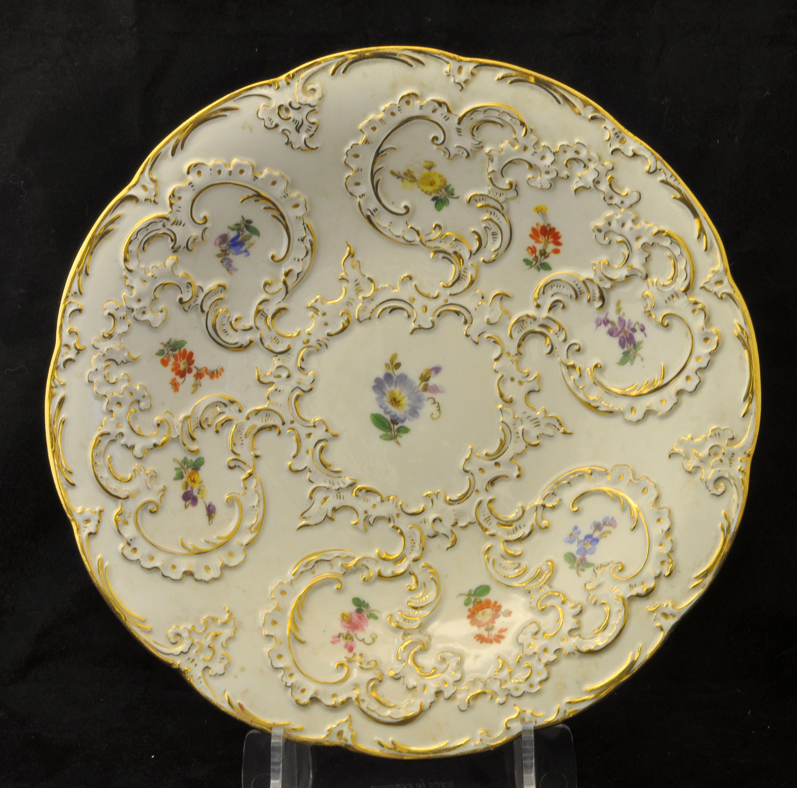 A Meissen circular Saucer Dish decorated with floral sprays and raised gilt scrolls, 9 1/2" (