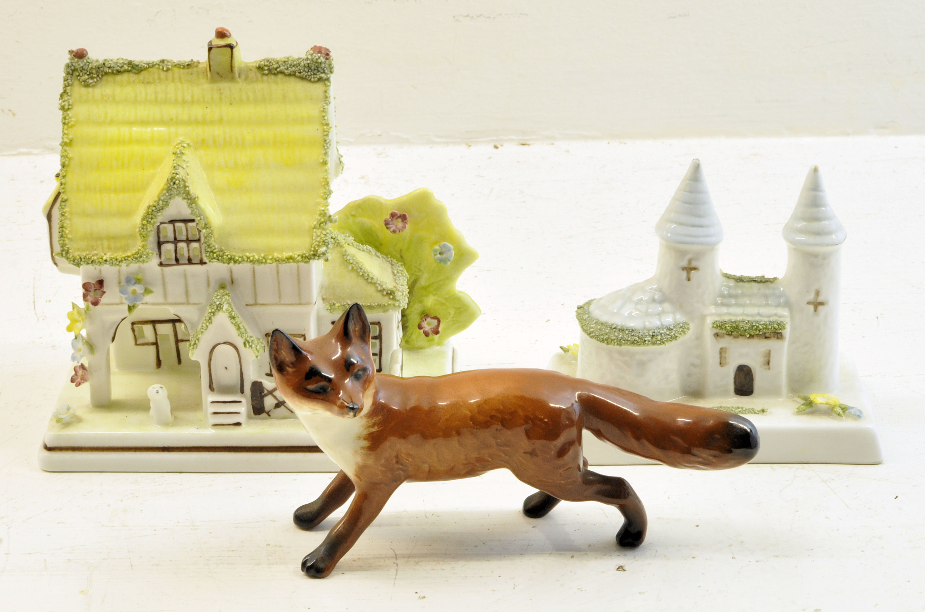 A Beswick Model of a Fox no. 1440, pre-1967; a Coalport Cottage "The Master's House", and a Coalport