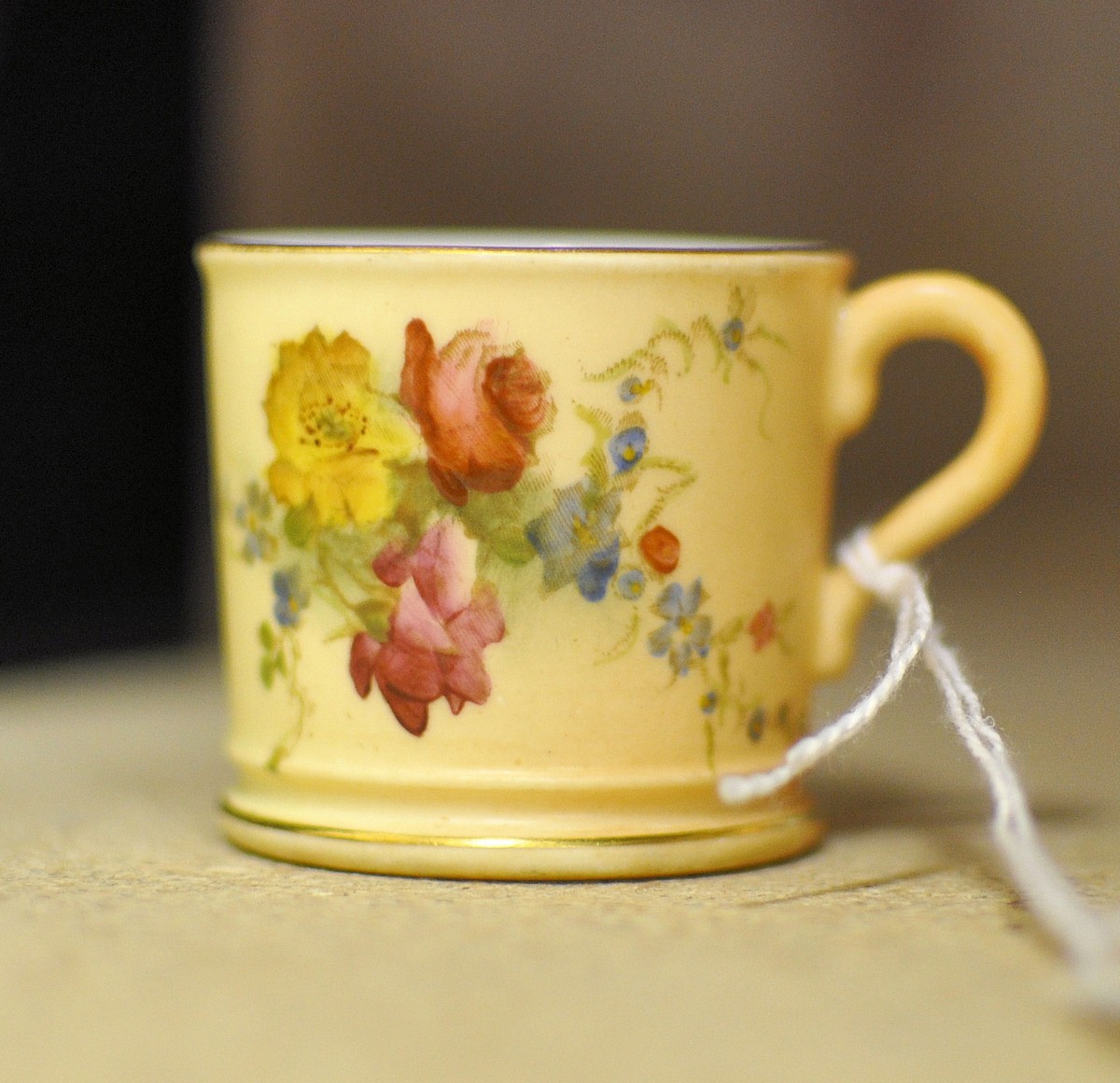 A Royal Worcester miniature Cup painted with sprays of flowers on a blush ivory ground, date code