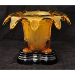 An amber glass Vase with turned over rim, decorated with reeds and bullrushes on a black glass