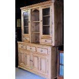 A pine Dresser, the upper section with open centre shelves flanked pair of glazed display