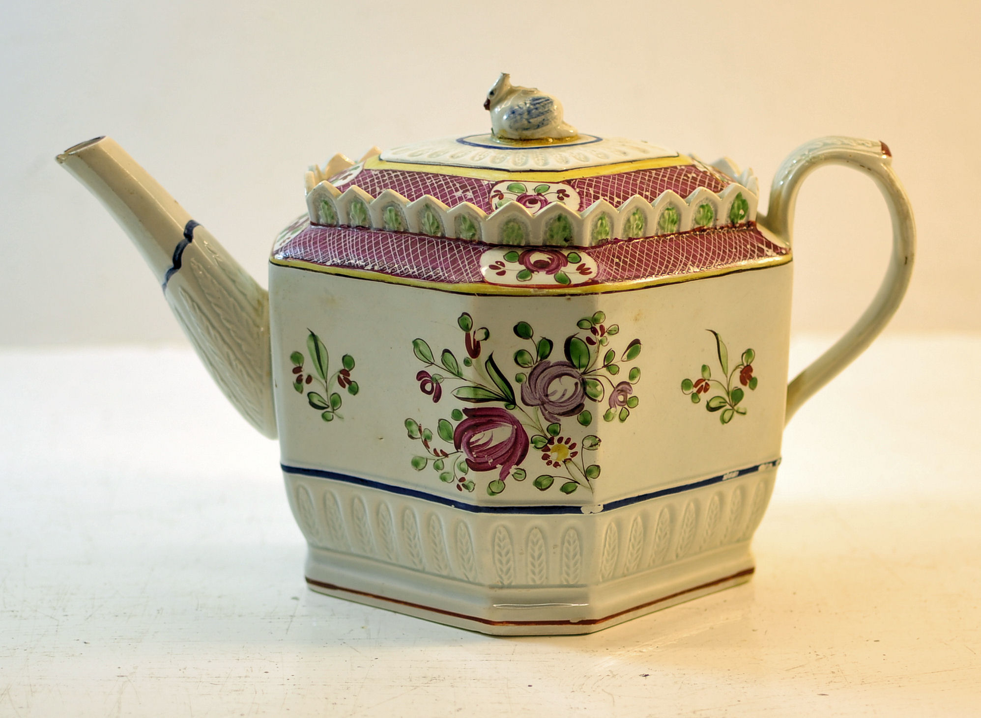 An early 19th century English Teapot of octagonal design, painted with sprays of flowers within a