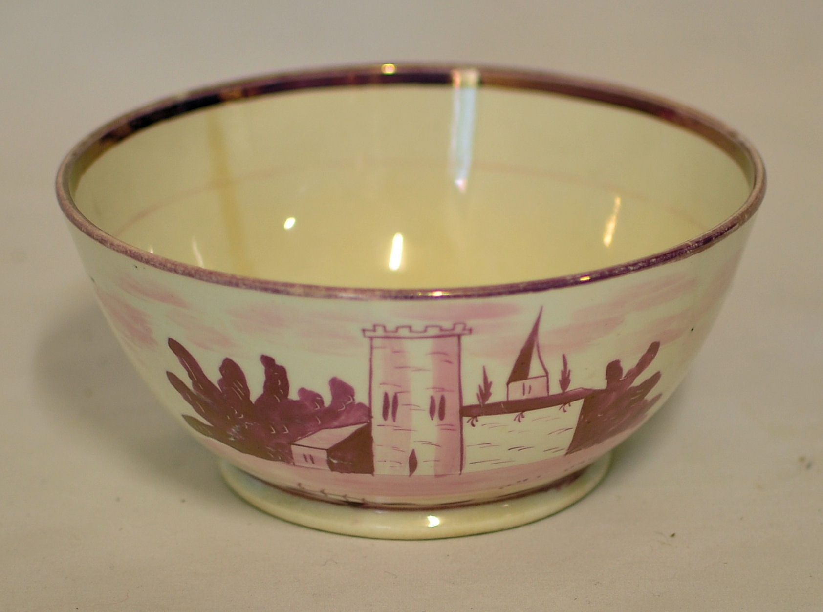 A 19th century pink lustre Bowl decorated with a church, 6" (15cms) diameter, and a lustre Cup and