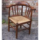 An 18th century design elm frame Corner Chair with spindle turned back, rush seat and turned