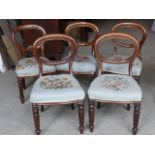 A set of four early Victorian mahogany frame Dining Chairs with oval backs, needlework seats, and