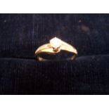 A 9ct gold Dress Ring with a solitaire diamond and diamond set shoulders.