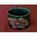 A Moorcroft oval Toothpick Holder decorated with Clematis on a shaded green ground, and with paper