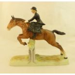 A Beswick Model of a Huntswoman on a horse jumping a wall, no. 982.